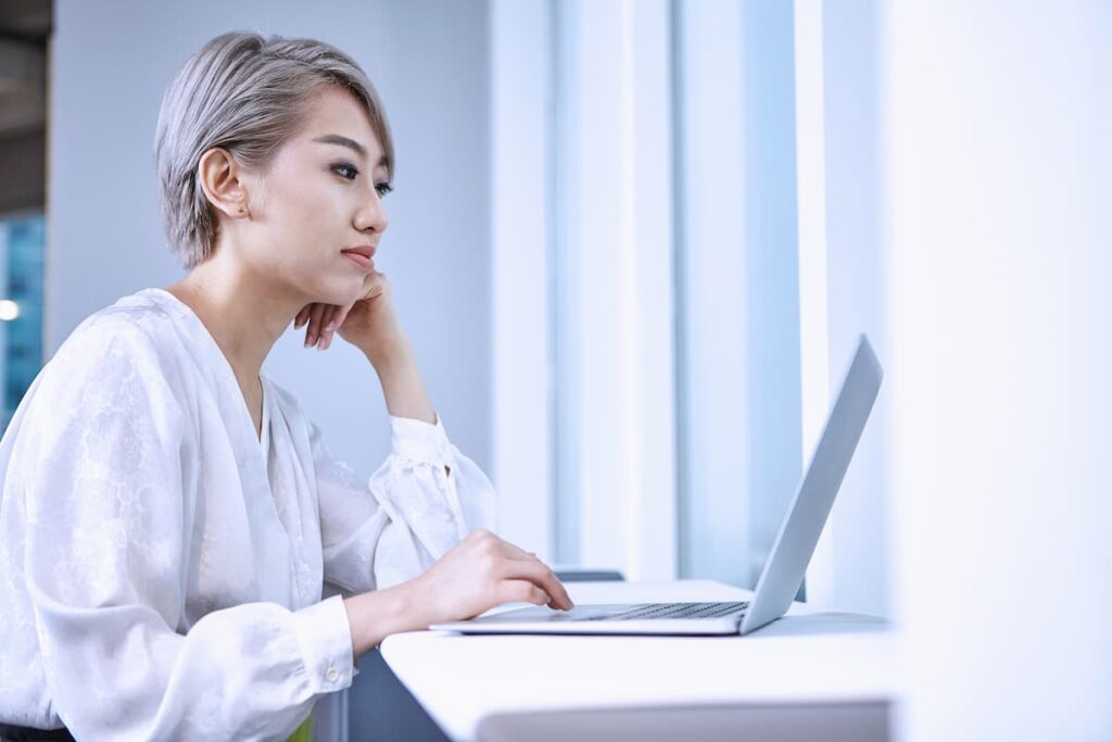 女性が家でノートパソコンを使って仕事をしている